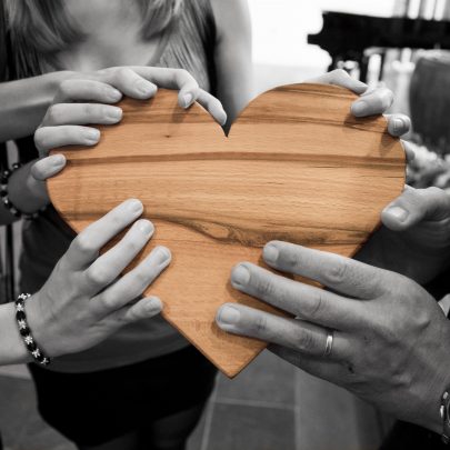 Hands holding wooden heart